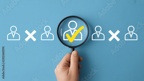 A hand uses a magnifying glass to find the right candidate among abstract person icons on a blue background