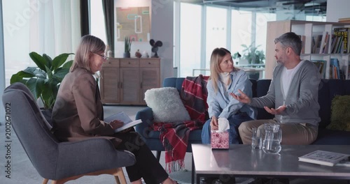 Caucasian family professional therapist listening to married couple complaining their relationship problems conflicting inside apartment. Therapy session. Mental health.