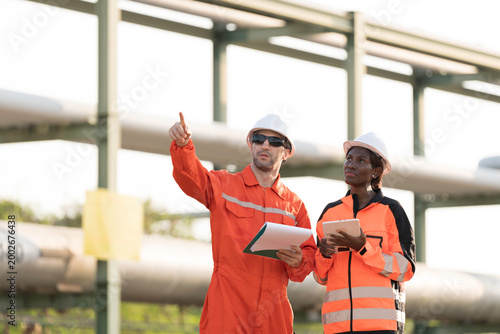 Oil refinery or Petroleum refinery. Gas pipeline network system at the industrial estate area. Petrochemical engineer inspecting gas pipeline, valves and mechanisms at industrial estate