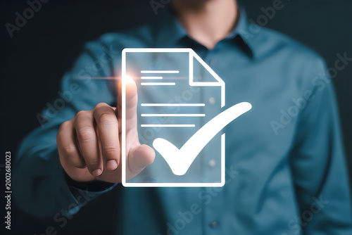 Person in blue shirt touching a glowing digital document with checkmark