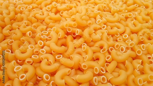 Elbow Macaroni Pasta Dropping on Uncooked Elbow Macaroni Ingredient, Food Background