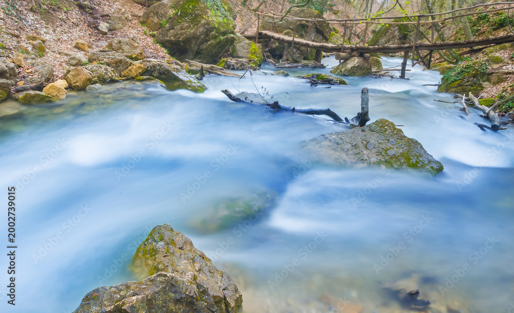 Fototapeta premium small river rushing over a stones in the mountain canyon