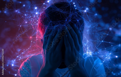 Amidst a dazzling computer network, an overwhelmed guy covered his face with his hands. Conceptual representation of cyber stress and information overload