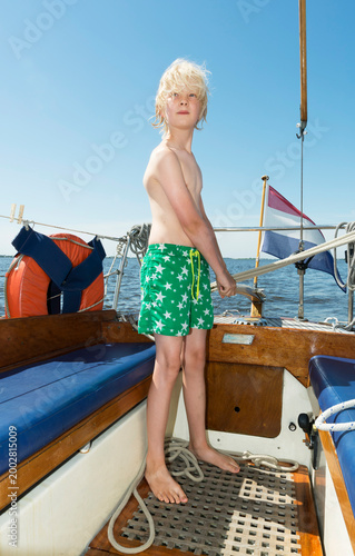 Sailor steering a sailboat in the Frisian lake district