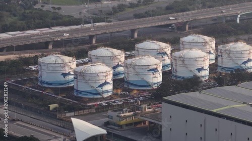 Aerial view of industrial oil storage tanks and highway traffic