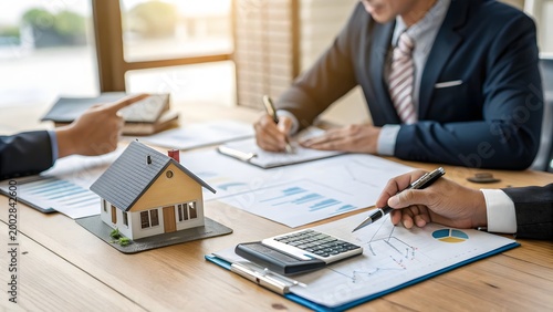 professional business meeting with real estate planning and financial documents on wooden table