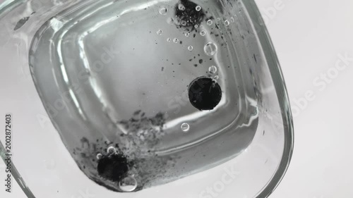 Effervescent tablet. Black medicinal tablets. Water. Glass. slow motion video. High quality footage 4k