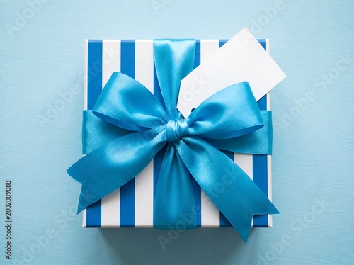 A beautifully wrapped gift box with a blue ribbon on a light blue background for birthday or holiday celebrations