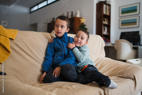 Obraz na plátne Two young brothers bonding together, with the younger boy embracing the older on