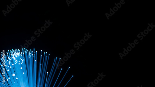 Glowing blue fiber optic strands close-up with fiber optics, technology