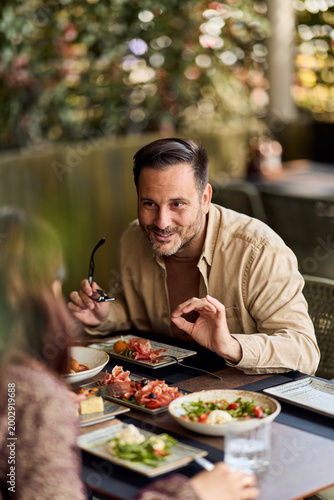 фотографія Smiling Man Conversing With Friend Over Casual Lunch At Outdoor Cafe — Social Br