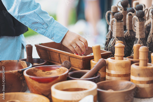 Φωτογραφία A person reaches into a wooden bowl at a craft fair