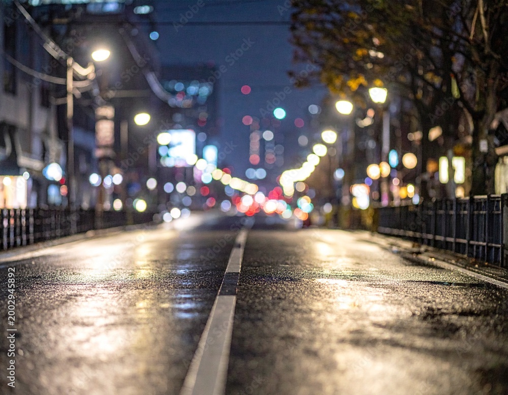 Fototapeta premium Dark Blurred Night Street Background with Glowing Street Lights Bokeh