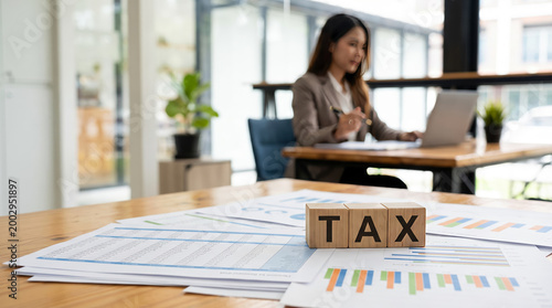 Business tax accounting concept with TAX letters on financial report, laptop, and professional advisor