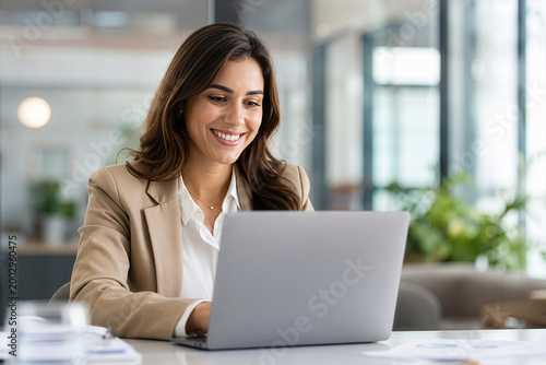 A professional consultant smiling warmly while looking at a laptop. Free Download A professional consultant smiling warmly while looking at a laptop. - GFXLoad