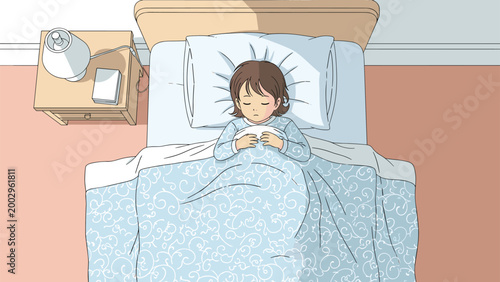 Top view of young child sleeping peacefully in comfortable bed under blue patterned blanket during night time.