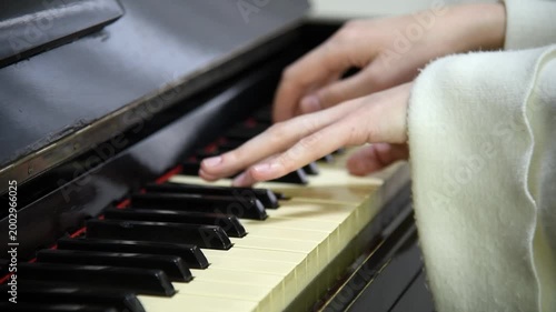 female pianist hands on black and white piano keyboard, close-up view, young woman playing piano, professional musician