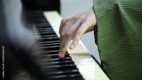 female pianist hands on black and white piano keyboard, close-up view, young woman playing piano, professional musician
