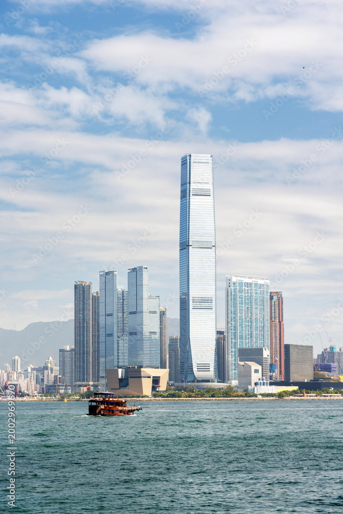 Fototapeta premium Hong Kong skyscraper panorama on a sunny day with water and boats