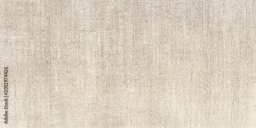 Soft focus on an old, textured, beige linen cloth revealing the detailed weave of the fabric, highlighting its inherent elegance.