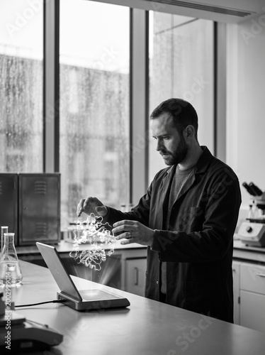 Male Scientist Interacting with a 3D Protein Structure Hologram in a Modern Laboratory