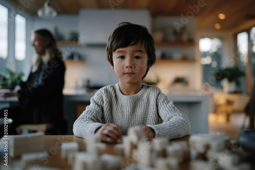 A serene portrait of a young boy displaying calm concentration while engaged in play, reflecting the beauty of childhood moments and the importance of creativity in a cozy environment.