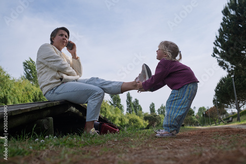 Fotografía Seeking Attention: Toddler Girl Trying to Distract Her Mother from Smartphone in