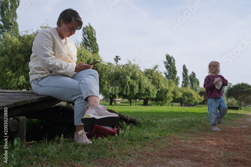 Obraz na płótnie Seeking Attention: Toddler Girl Trying to Distract Her Mother from Smartphone in