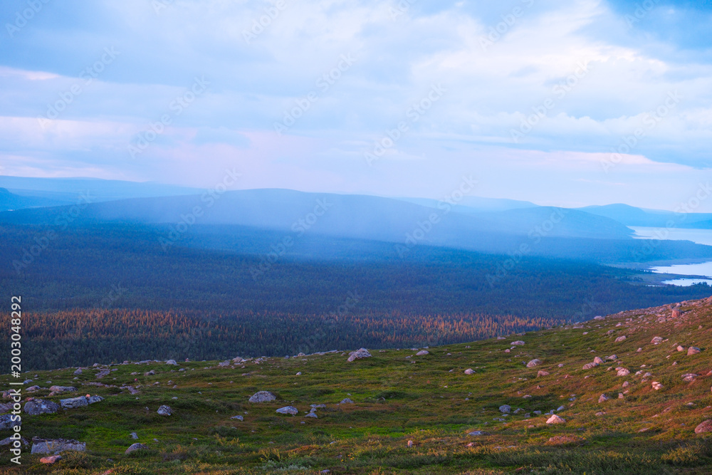 Fototapeta premium Majestic sunset over Kungsleden hiking trail in Laponia Sweden with golden light illuminating arctic tundra and mountain peaks