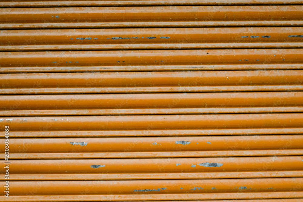Fototapeta premium Orange metal shutter texture, industrial striped background