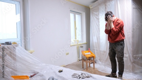 Quadro su tela Man holding hands to his head feeling upset and exhausted during a stressful hom