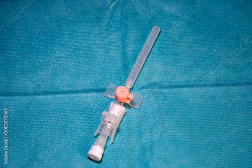 Tableau sur toile Medical IV cannula peripheral venous catheter on blue sterile surgical backgroun