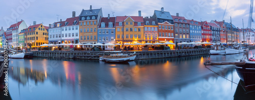 Bild auf Leinwand Quiet Nyhavn waterfront at dawn with moored boats, calm canal reflections, and soft early morning light in Copenhagen, Denmark