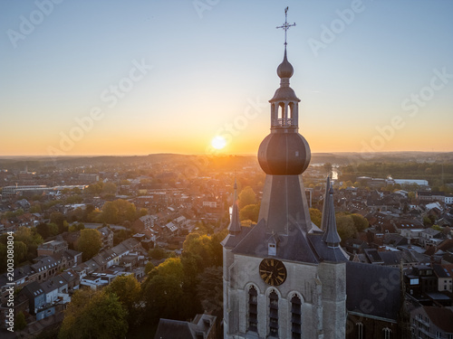 Valokuva Historic church bell tower at sunset in België - aerial drone view of traditiona