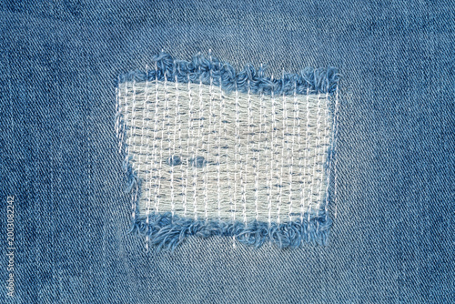 Fotografie Denim fabric with a patch showing textile repair work being done on a piece of c