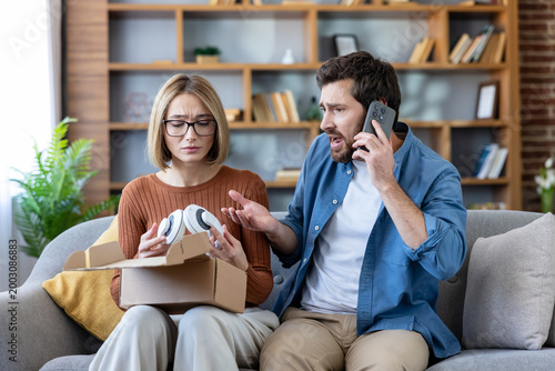 Fotografie Angry Caucasian man on phone call complaining about broken headphones and delivery scam while woman looks upset