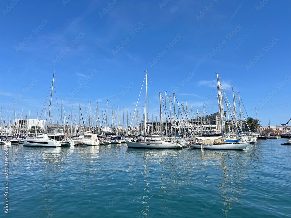 Fototapeta premium Luxury yachts and sailboat masts reflecting in calm blue water. Abstract nautical background for travel, charter, waterfront real estate and lifestyle branding.