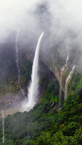 Majestic nohkalikai Waterfall of Meghalaya Cascading Down High Cliff into Mist, Lush Green Tropical Forest Mountainside with Foggy Atmosphere and Scenic Nature Landscape