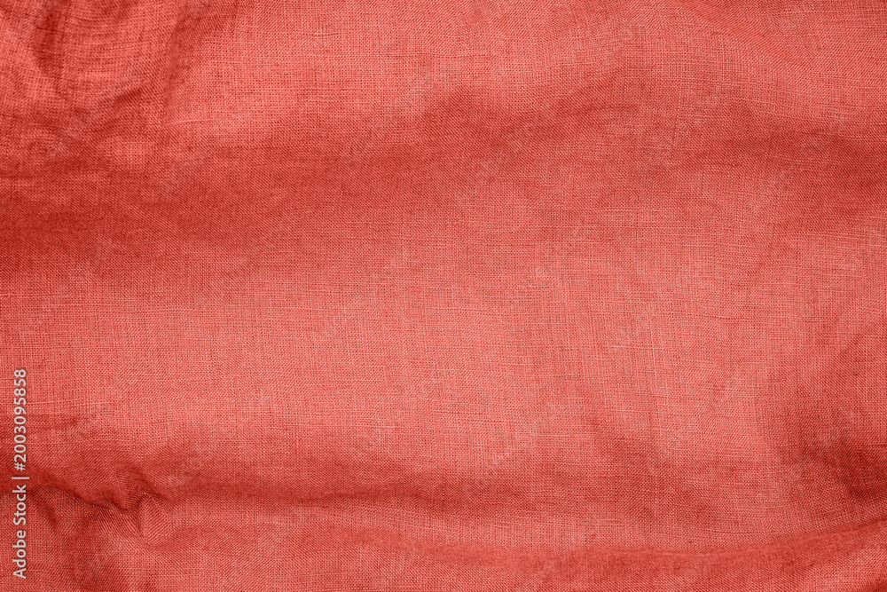 Fototapeta premium Red fabric with a woven texture is displayed on a simple background in a well-lit setting during daylight hours