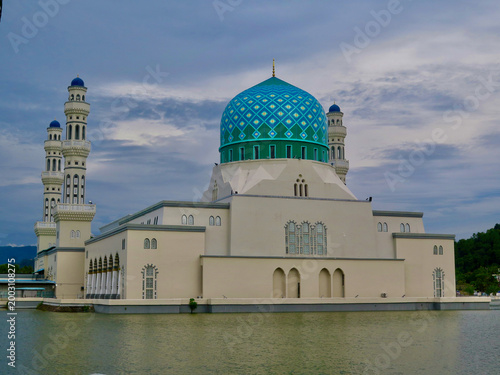 Floating Mosque in Kota Kinabalu, Sabah, Malaysia with blue dome over water. Iconic floating mosque with Islamic architecture and calm reflective lagoon.