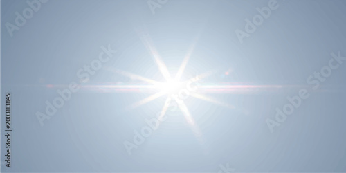 A bright summer sunrise illuminates an abstract blue sky with glowing sunlight rays and a brilliant star burst flare shining through the clouds for a nature design