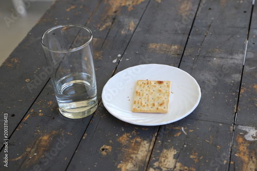 Foto Glass of water with a plate of saltine crackers on a wooden table with a background and copy space