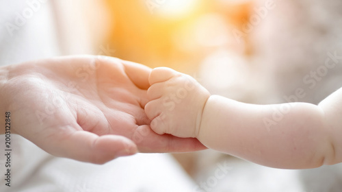 Mother's hand holding a little baby's hand, palms, fingers, Mother's Day, motherhood, child care, mom and kid