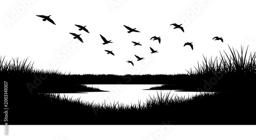 Silhouette of birds in flight over a tranquil wetland landscape at dusk