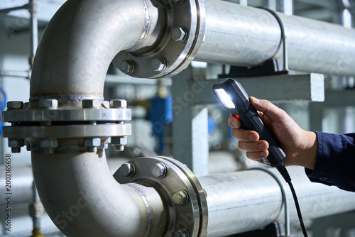 Konstfotografi Industrial pipe inspection with a flashlight, checking for leaks and damage in a