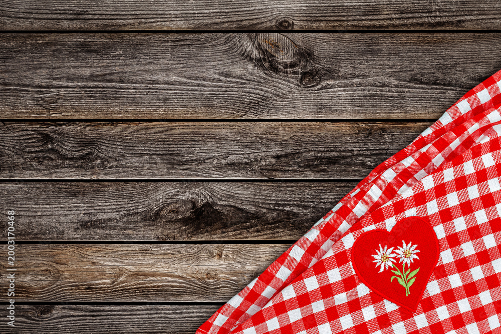 Fototapeta premium Checkered table cloth with a heart design and floral pattern on wooden surface in a kitchen setting