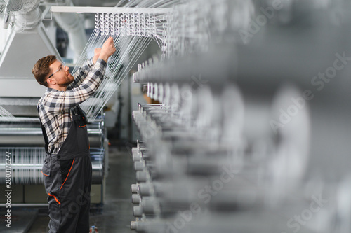 Schilderij op canvas Factory worker adjusting polypropylene yarn production line