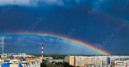 Fantastic beautiful rainbow over city buildings after rain