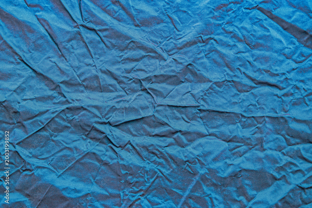 Fototapeta premium Vibrant blue silk taffeta textile with folds wrinkles and glossy texture.