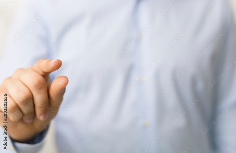 Naklejka premium Close-up of a man's hand pointing with the index finger. Focus on the gesture.
